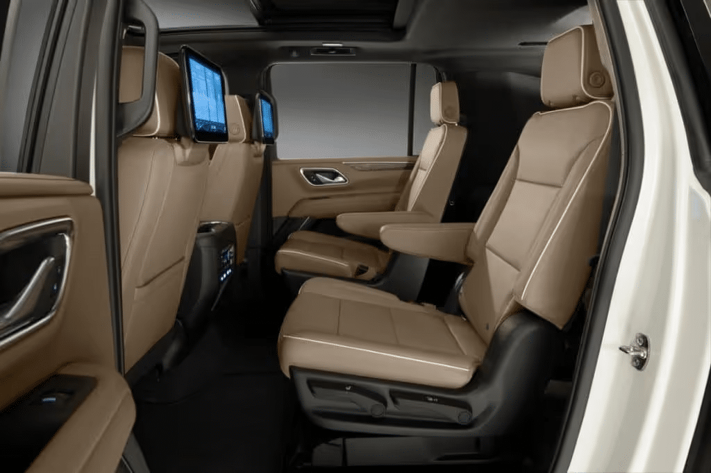 Luxurious and spacious interior of a modern SUV featuring high-quality tan leather seats, individual entertainment screens, and a sophisticated cabin design, perfect for family travel and comfort.