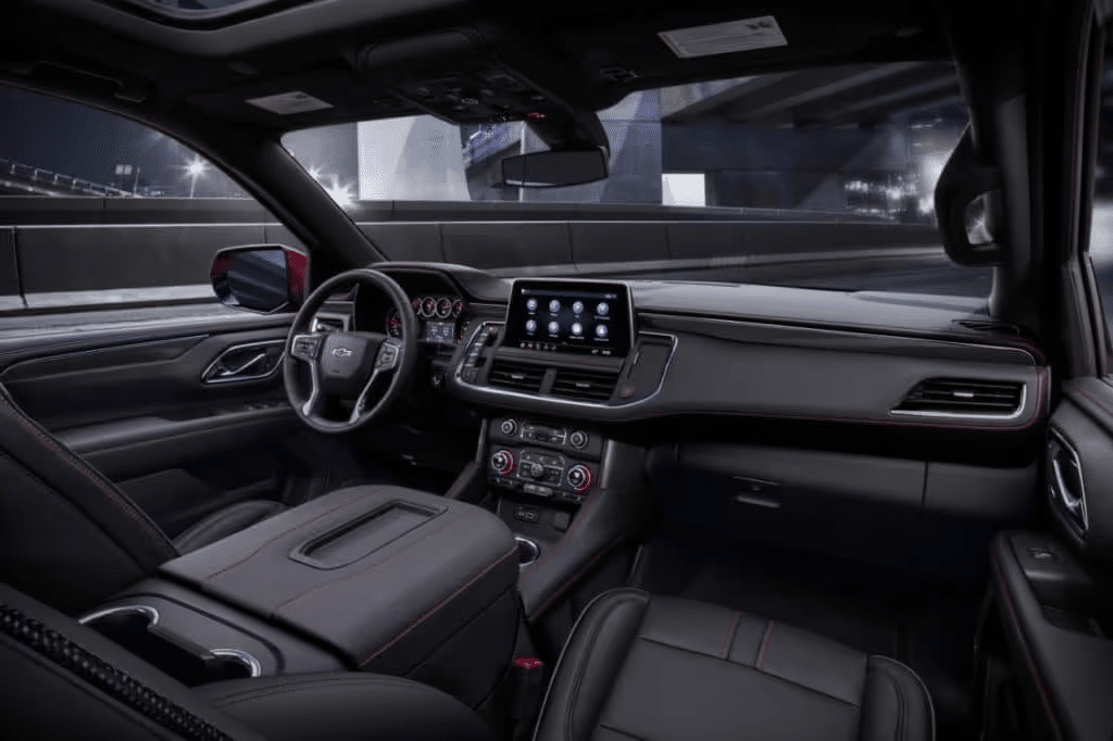 Interior view of a modern car showcasing a sleek dashboard, high-tech infotainment system, and stylish leather upholstery, illuminated by ambient lighting, designed for comfort and convenience during nighttime driving.