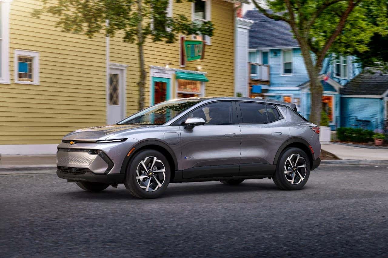 Chevrolet electric SUV parked on a street with colorful buildings, showcasing its modern design and sleek lines, emphasizing urban mobility and sustainable driving.