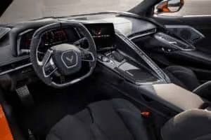 Interior view of a Chevrolet Corvette, showcasing a sleek dashboard, modern infotainment system, and sporty steering wheel with high-quality upholstery. The design emphasizes luxury and performance features in a contemporary sports car.