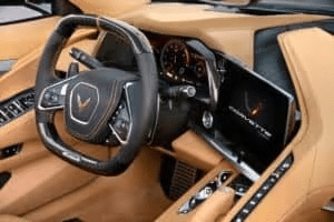 Interior of a luxury sports car featuring a modern dashboard, leather seats, and a sleek design with a prominent steering wheel and touchscreen display.