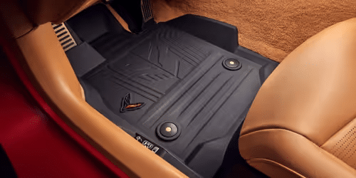 Vehicle floor mats featuring a textured black rubber design, custom-fitted for luxury car interiors, providing protection against dirt and wear.