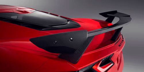 2020 Chevrolet Corvette C8 rear view showcasing its sleek design, distinctive taillights, and aerodynamic spoiler in a striking white finish.
