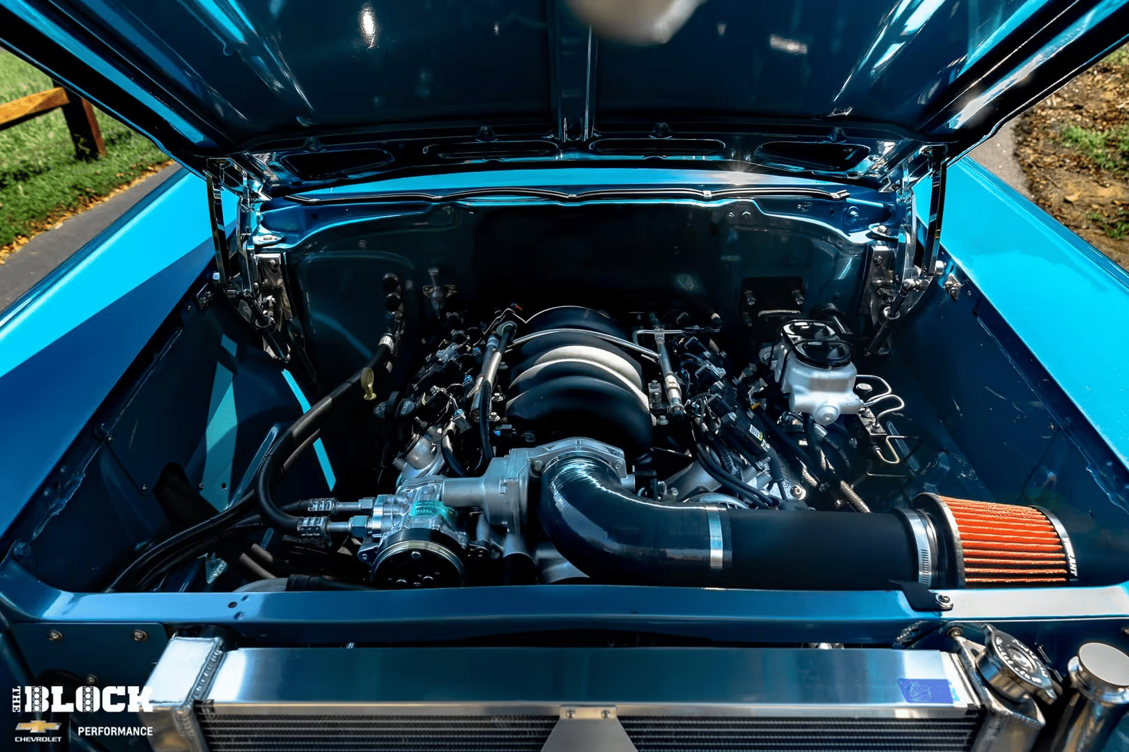 Engine compartment featuring a turbocharged LTR engine with a distinctive red and black valve cover, showcasing high-performance components and sleek design. Ideal for automotive enthusiasts and performance car builders.