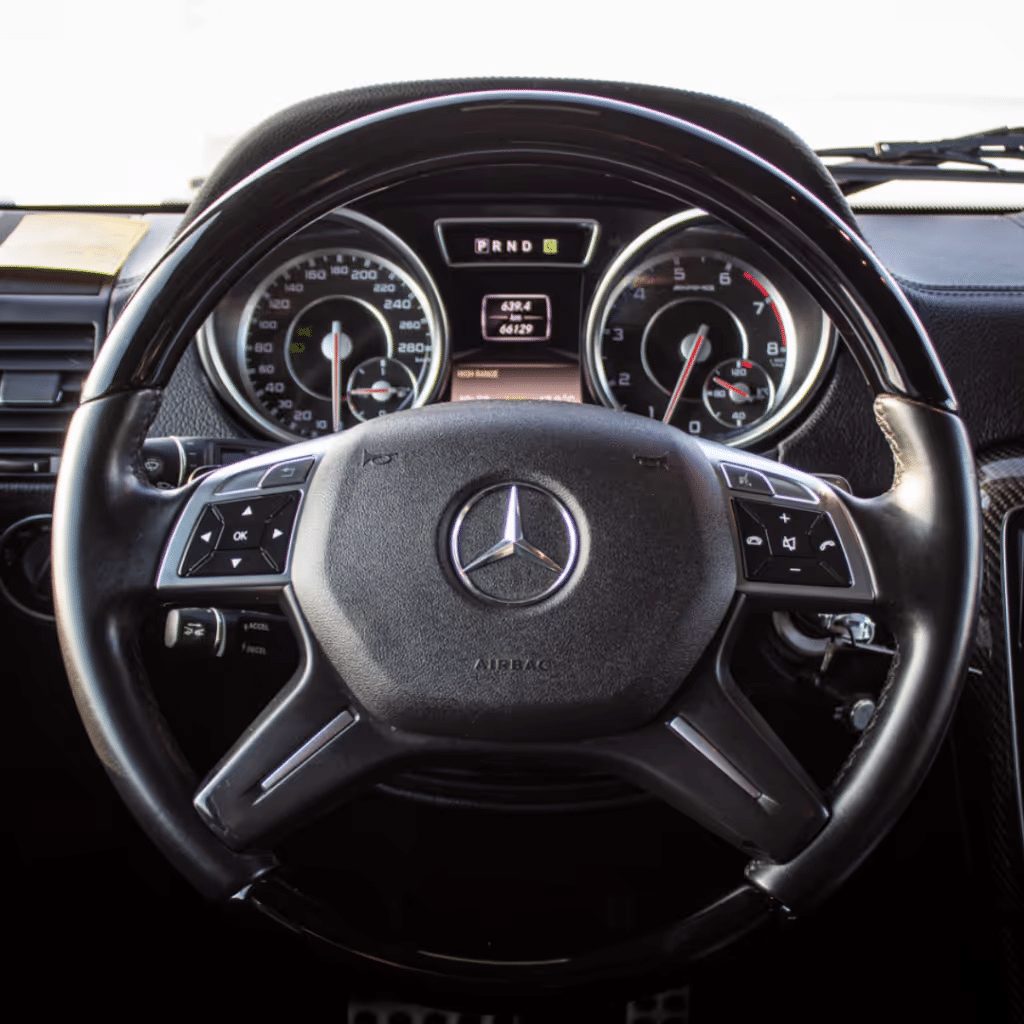 High-quality image of a Mercedes-Benz steering wheel and dashboard, featuring digital speedometer and odometer displays, as well as control buttons integrated into the steering wheel. Ideal for automotive enthusiasts and those interested in car interiors.