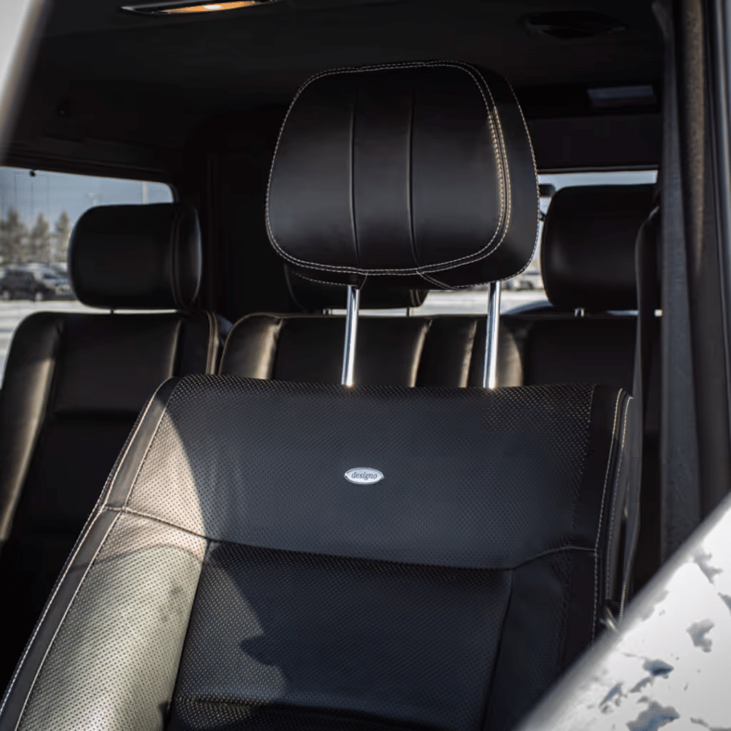 Black leather car seat with a headrest, designed for comfort and style, showcasing a sleek interior of a luxury vehicle.