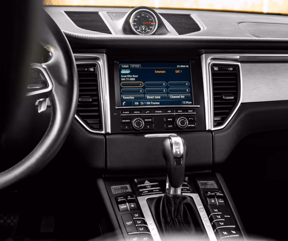 Interior view of a luxury car dashboard featuring a modern infotainment system with a touchscreen display, displaying radio options and entertainment features. The gear shift and controls are visible, highlighting the stylish design and advanced technology of the vehicle.