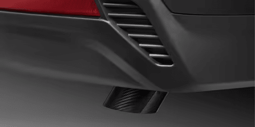 Close-up view of a car's exhaust tip, showcasing a sleek design integrated into the rear bumper, highlighting automotive performance and style.