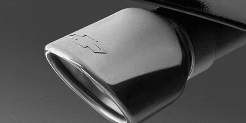 Close-up view of a car's exhaust tip, showcasing a sleek design integrated into the rear bumper, highlighting automotive performance and style.