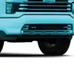 Front view of a blue truck highlighting its bumper, grille, and wheel, showcasing modern design and utility features.