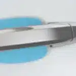 Close-up view of a sleek, modern pen with a metallic finish, resting on a light blue background, showcasing its ergonomic design and attention to detail.