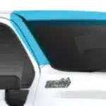 Close-up view of a truck's cab featuring a stylish blue visor above the driver's side window, highlighting the vehicle's modern design and functionality.