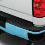 Close-up view of a vehicle's rear bumper with a blue protective cover and tail light.