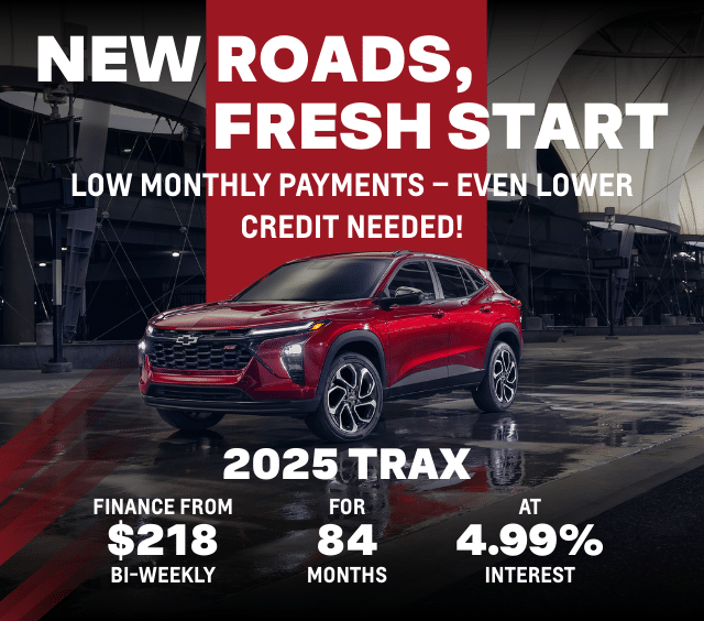 2025 Chevrolet Trax in red parked in an industrial setting, promoting financing options with low monthly payments starting at $218 bi-weekly for 84 months at 4.99% interest. Text highlights "New Roads, Fresh Start" and emphasizes low credit requirements.